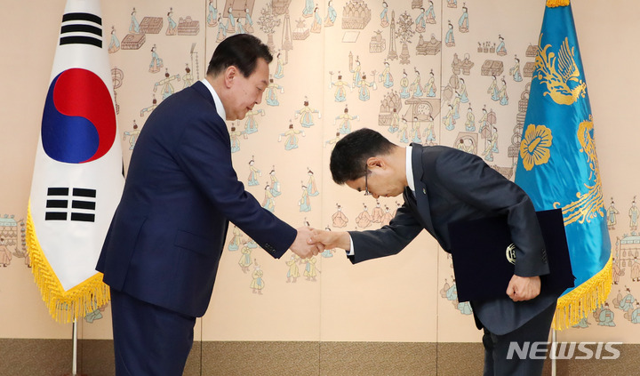 [서울=뉴시스] 홍효식 기자 = 윤석열 대통령이 14일 오전 서울 용산 대통령실 청사에서 김창기 국세청장에게 임명장을 수여한 후 악수하고 있다. 2022.06.14. yesphoto@newsis.com