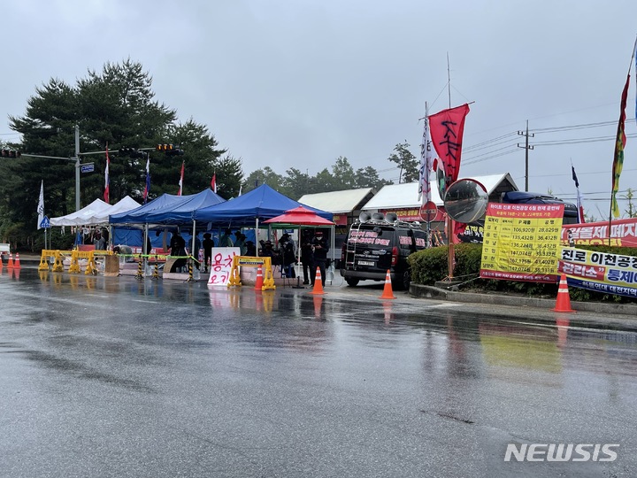 [서울=뉴시스] 15일 하이트진로 이천공장 정문에서 시위를 벌이고 있는 화물연대 소속 수양물류 화물차주들의 모습.(사진=하이트진로 제공)