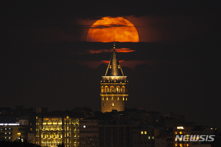 [이스탄불=AP/뉴시스] 14일(현지시간) 터키 이스탄불의 갈라타 타워 뒤에 슈퍼문이 떠오르고 있다. 달이 지구와 가까워 발생하는 '슈퍼문' 보름달은 6월에는 '스트로베리 문'(Strawberry Moon)이라고도 불린다. 2022.06.15.