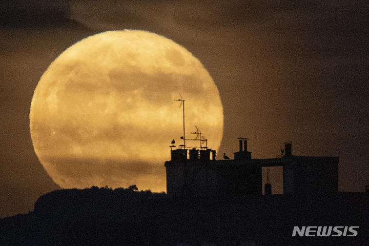 [마르세유=AP/뉴시스] 14일(현지시간) 프랑스 마르세유 건물 뒤 상공에 슈퍼문이 떠오르고 있다. 달이 지구와 가까워 발생하는 '슈퍼문' 보름달은 6월에는 '스트로베리 문'(Strawberry Moon)이라고도 불린다. 2022.06.15.