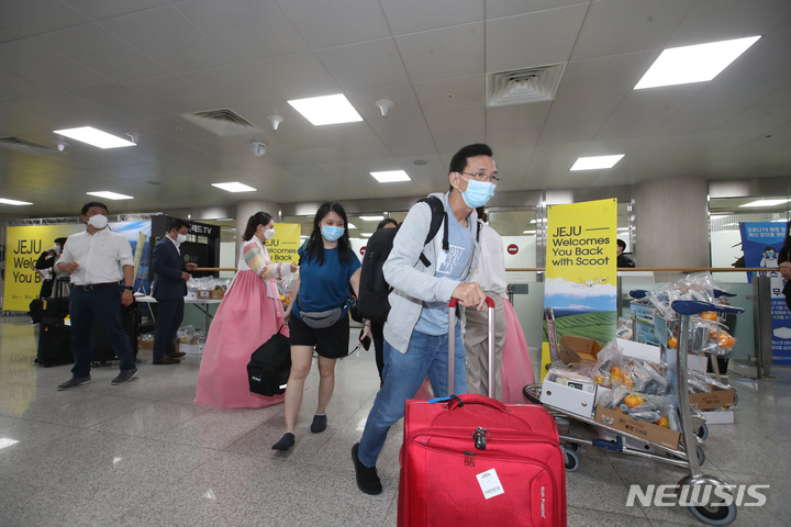 [제주=뉴시스] 우장호 기자 = 제주-싱가포르 직항 노선이 취항한 15일 오전 제주국제공항 1층 도착장에 스쿠트항공 TR812편을 타고 온 싱가포르 관광객들이 들어서고 있다. 제주공항의 국제 직항노선 취항은 코로나19로 인해 지난 2020년 4월 6일 인천국제공항 검역일원화에 다른 입국제한 조치 시행 후 2년 2개월만이다. 2022.06.15. woo1223@newsis.com