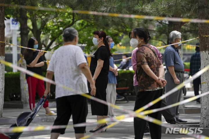 [베이징=AP/뉴시스] 15일 중국 베이징에서 마스크를 쓴 시민들이 코로나19 검사를 받기 위해 줄 서 있다. 베이징의 코로나19 재확산이 계속되고 위성도시에서도 확진자가 발생하는 것으로 알려졌다. 2022.06.15.