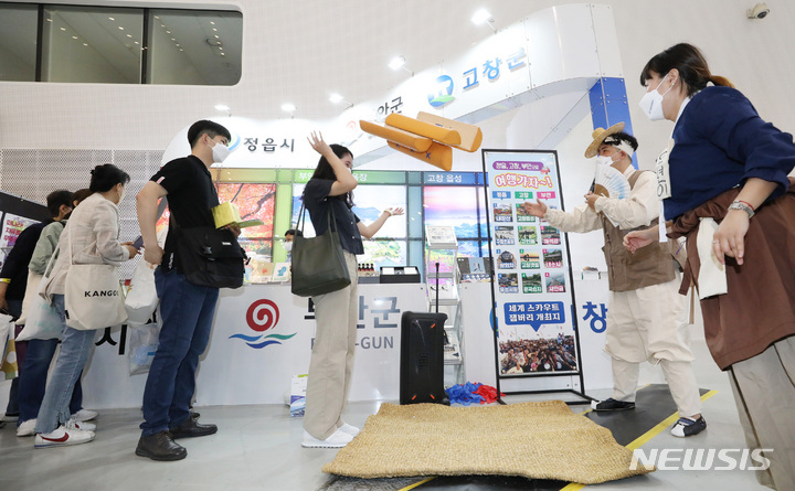 [서울=뉴시스] 김진아 기자 = 16일 서울 동대문디자인플라자에서 열린 '2022 내나라 여행박람회'에 참가한 관람객들이 지역 홍보부스를 이벤트에 참여하고 있다. 2022.06.16. bluesoda@newsis.com