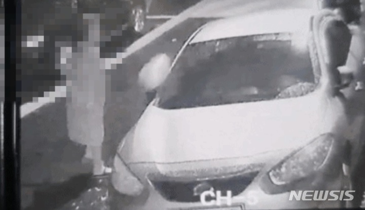 [서울=뉴시스]여성이 A씨 차량에 음식물 쓰레기 통을 던지고 있다. 온라인 커뮤니티 캡처