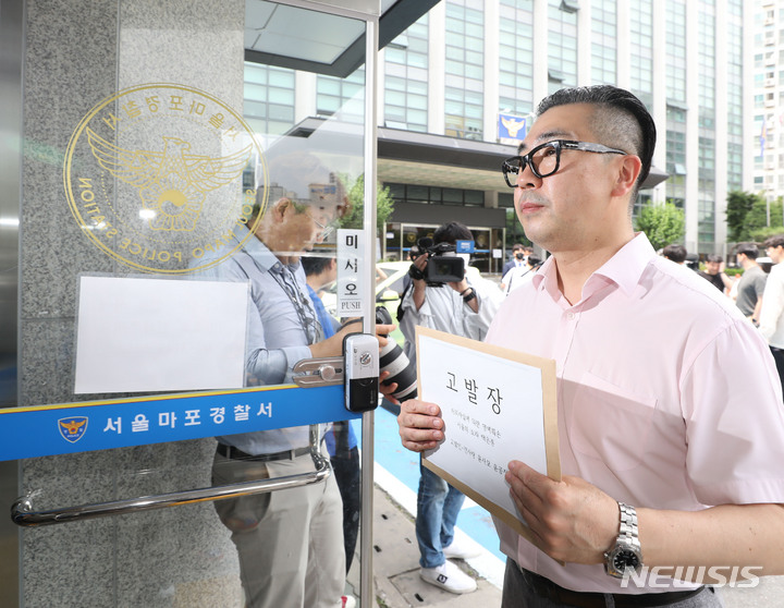 [서울=뉴시스] 조수정 기자 = 윤석열 대통령 부인 김건희 여사 팬카페 '건사랑' 대표 이승환 씨가 지난 20일 오후 서울 마포경찰서 민원실에 서울의소리 백은종 대표를 허위사실에 의한 명예훼손으로 고발하기 위해 고발장을 들고 들어서고 있다. 2022.06.20. chocrystal@newsis.com