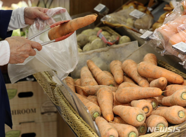 [서울=뉴시스] 김금보 기자 = 20일부터 전국 대형마트에서 평소 묶음 포장 판매하던 양파와 파프리카 등을 낱개로 원하는 수량 만큼 구매할 수 있게 된다. 이날 서울 중구 한 대형마트에서 시민이 당근을 구매하고 있다. 2022.06.20. kgb@newsis.com