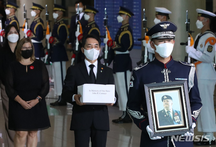 [인천공항=뉴시스] 조수정 기자 = 고(故) 존 로버트 코미어 캐나다 6·25 참전용사 유해 봉환식이 엄수된 20일 오후 인천국제공항 제1터미널에서 박민식(오른쪽 앞에서 두번째) 국가보훈처장이 유족인 조카 미쉘 코미어(오른쪽 앞에서 세번째) 씨로부터 전달받은 유골함을 봉송 차량으로 모시고 있다. 고인은 1952년 4월 2일부터 1953년 4월 25일까지 6·25에 참전했다. 생전에 "한국에 묻히고 싶다"는 고인의 의지에 따라 부산 유엔기념공원에 안장한다. 2022.06.20. chocrystal@newsis.com