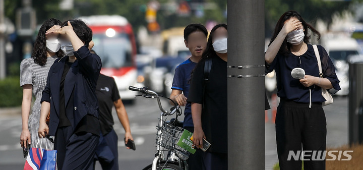 [서울=뉴시스] 정병혁 기자 = 절기상 하지이자 서울 낮 최고기온이 33도까지 오를 것으로 예보된 21일 오전 서울 종로구 광화문네거리에서 시민들이 손으로 햇빛을 가린 채 신호를 기다리고 있다. 2022.06.21. jhope@newsis.com