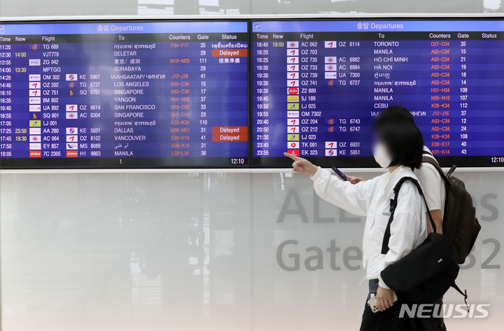 [인천공항=뉴시스] 조성우 기자 = 지난 21일 오후 인천국제공항 제1여객터미널에서 공항 이용객들이 항공편 정보가 나오는 전광판 앞을 지나고 있다. 2022.06.22. xconfind@newsis.com