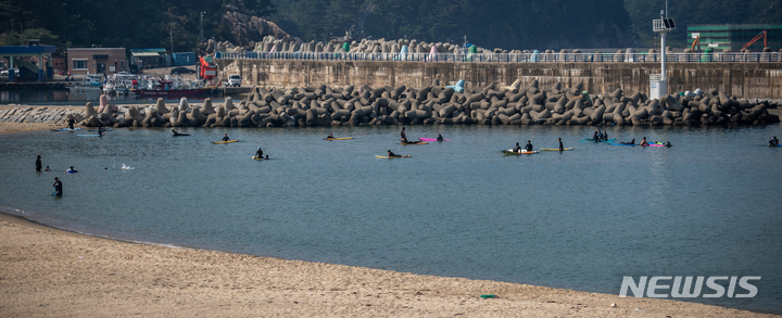 [양양=뉴시스] 정병혁 기자 = 강원 양양군에 위치한 38선휴게소 인근 기사문해변에서 서핑을 배우는 관광객들. 2022.06.25. jhope@newsis.com