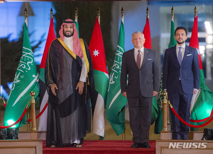 [ 암만( 요르단)= AP/뉴시스]요르단의 압둘라2세 국왕(가운데)이 6월21일 요르단을 방문한 모하메드 빈 살만 사우디왕세자(왼쪽), 후세인 빈 압둘라 요르단 왕세자와 함께 암마의 퀸 알리아 국제공항에서 환영식을 거행하고 있다. 