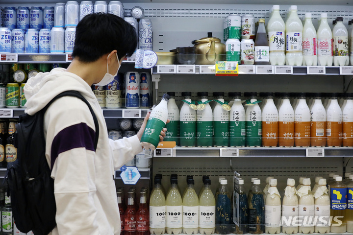 [서울=뉴시스] 김진아 기자 = MZ세대(밀레니얼+Z세대)의 막걸리 소비가 늘어나면서 막걸리가 제2의 전성기를 맞고 있다. 22일 한국농수산식품유통공사(aT)에 따르면 2016년 이전까지 3000억원대에 그쳤던 국내 막걸리 소매시장 규모는 2019년 4500억원대로 급성장했다. aT는 지난해에는 시장 규모가 5000억원을 돌파했을 것으로 추정한다.&nbsp; 22일 서울 롯데마트 서울역점에서 고객이 막걸리를 고르고 있다. 2022.06.22. bluesoda@newsis.com