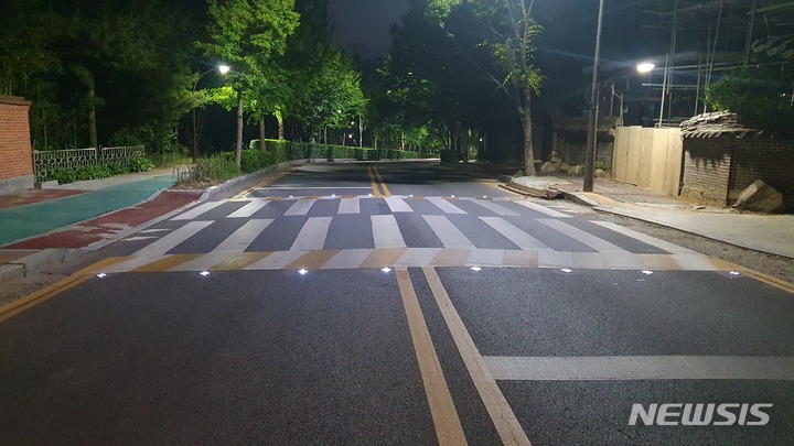 LED 활주로형 표지병이 설치된 야간 횡단보도 현장.