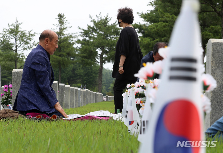 [서울=뉴시스] 이영환 기자 = 6.25전쟁 72주년을 하루 앞둔 24일 오전 서울 동작구 국립서울현충원 34묘역에서 참배객들이 참배를 하고 있다. 2022.06.24. 20hwan@newsis.com