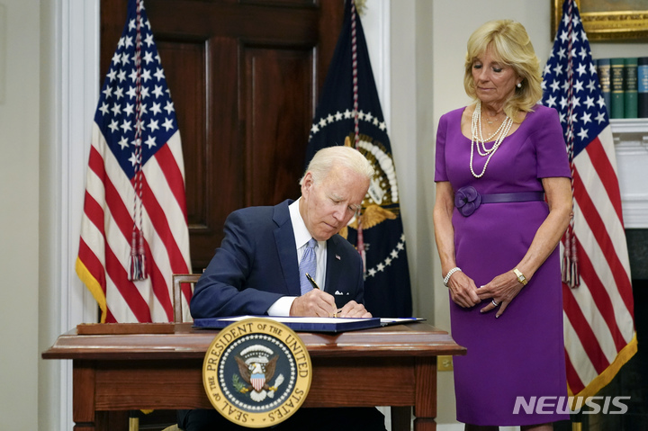 [워싱턴=AP/뉴시스] 조 바이든 미국 대통령이 25일(현지시간) 백악관 루스벨트룸에서 질 바이든 여사가 지켜보는 가운데 미 의회를 통과한 초당적 총기규제법안에 서명하고 있다. 2022.06.25