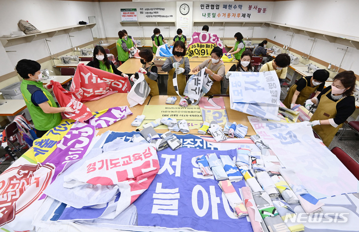 [수원=뉴시스] 김종택기자 = 2022년 6월28일 오전 경기도 수원시 팔달구 수원시가족여성회관에서 경기도여성단체협의회수원시지회 회원들과 수원시가족여성회관 관계자들이 지난 전국동시지방선거 기간동안 게시됐던 폐현수막 등으로 낙엽 수거용 자루를 만들고 있다. 2024.04.08.