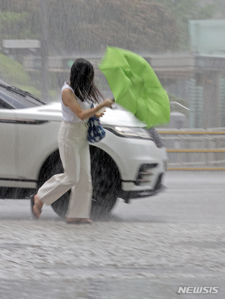 [서울=뉴시스] 김금보 기자 = 국지성 호우가 쏟아진 28일 오후 서울시 중구 을지로1가사거리인근에서 한 시민이 비바람에 고장 난 우산을 들고 이동하고 있다. 2022.06.28. kgb@newsis.com