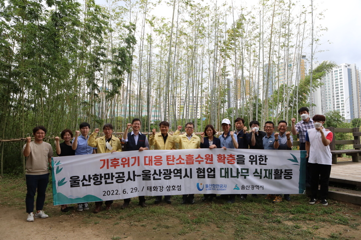 [울산=뉴시스]29일 울산시와 울산항만공사 관계자들이 울산 남구 태화강 삼호교 인근 삼호섬에서 8~10년생 대나무 150주를 식재한 뒤 기념촬영을 하고 있다. (사진=울산항만공사 제공) 2022.06.29. photo@newsis.com *재판매 및 DB 금지