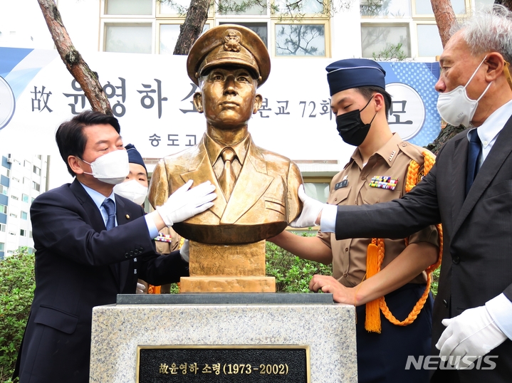 [인천=뉴시스] 김동영 기자 = 국민의힘 안철수 의원(왼쪽)이 29일 오후 인천 연수구 송도고등학교에서 열린 제20주기 故 윤영하 소령 추모식에서 윤 소령 흉상의 빗물을 닦고 있다. 2022.06.29. dy0121@newsis.com 