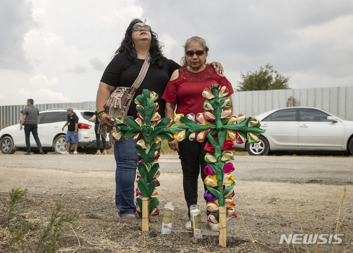 [샌안토니오=AP/뉴시스] 28일(현지시간) 미 텍사스주 샌안토니오의 멕시코 이민자 집단 사망 현장 인근에서 두 여성이 조의를 표하고 있다. 앞선 27일 이곳에 버려진 트레일러 안에서 멕시코 이민자로 추정되는 사람들의 시신 50구가 발견됐다. 2022.06.29.