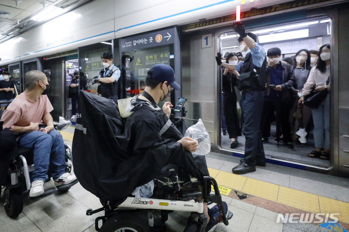 [서울=뉴시스] 최동준 기자 = 전국장애인차별철폐연대가 30일 서울 지하철 4호선 충무로역에서 장애인 권리 예산 보장 등을 요구하며 지하철 승하차 시위를 하고 있다. 2022.06.30. photocdj@newsis.com