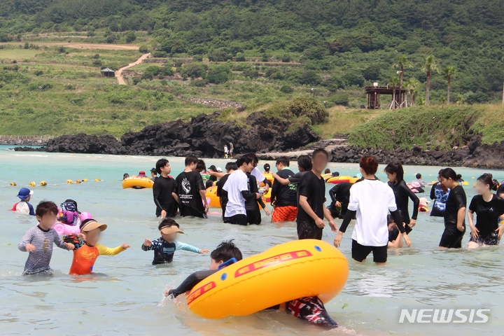 [제주=뉴시스] 양영전 기자 = 제주지역 해수욕장이 개장한 뒤 첫 주말을 맞은 2일 오후 제주 함덕해수욕장에서 피서객들이 물놀이를 즐기고 있다. 3년 만에 '노마스크'로 개장한 도내 12곳 해수욕장은 다음 달 31일까지 2개월간 오전 10시부터 오후 7시까지 운영된다. 2022.07.02. 0jeoni@newsis.com 