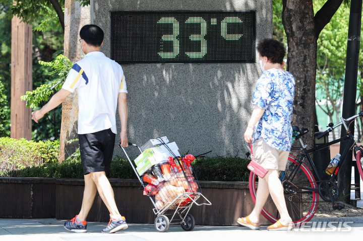[서울=뉴시스] 권창회 기자 = 서울을 비롯한 전국 곳곳에 폭염 주의보가 내려진 지난 3일 오후 서울 성동구 이마트 성수점 앞에 설치된 디지털 온도계가 33도를 나타내고 있다. 2022.07.03. kch0523@newsis.com