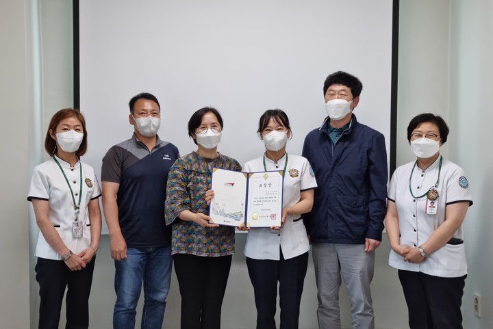 [서울=뉴시스]갑을녹산병원에서 주순남 간호부장(왼쪽에서 4번째)이 박영란 부산광역시 강서구 보건소 재택치료팀장(3번째)으로부터 부산시장 표창장을 전달받고 참석자들과 기념촬영을 하고 있다. (사진=KBI그룹 제공) *재판매 및 DB 금지