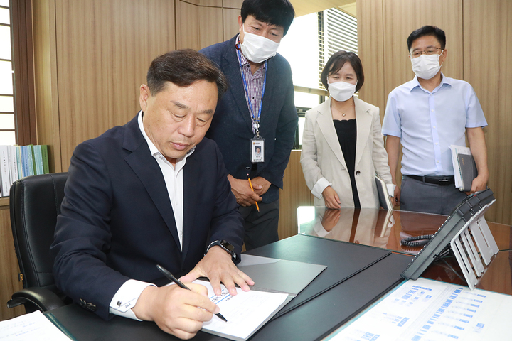 [울산=뉴시스] 박수지 기자 =김종훈 울산 동구청장이 4일 구청장실에서 1호 결재로 ‘동구 노동기금’ 조성에 서명을 하고 민선 9대 공식 업무를 시작했다. 2022.07.04. (사진=동구 제공) photo@newsis.com *재판매 및 DB 금지