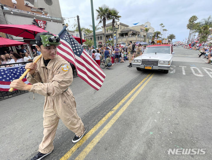 [헌팅턴비치=AP/뉴시스] 미국인들이 '애국심'이나 '종교', '자녀' 등의 가치를 과거에 비해 중요하게 생각하지 않는 것으로 나타났다. 이들을 제치고 '돈'이 현재 미국인들이 가장 선호하는 가치가 됐다. 사진은 지난해 7월4일(현지시간) 미 캘리포니아주 헌팅턴비치에서 제118회 헌팅턴비치 독립기념일 퍼레이드가 열려 고스트버스터 복장의 참가자가 성조기를 들고 행진하고 있다. 2022.07.05.