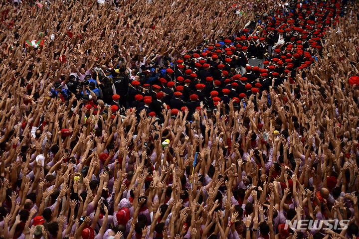 [팜플로나=AP/뉴시스] 6일(현지시간) 스페인 팜플로나 타운홀 광장에서 축제 참가자들이 '2022 산페르민 축제' 개막을 축하하는 연주를 보며 일제히 손을 들고 있다. 코로나19로 지난 2년간 중단됐던 축제가 9일간의 일정을 시작했으며 '엔시에로'라고 하는 소몰이 행사는 이 축제의 최대 인기 행사다. 2022.07.07. 