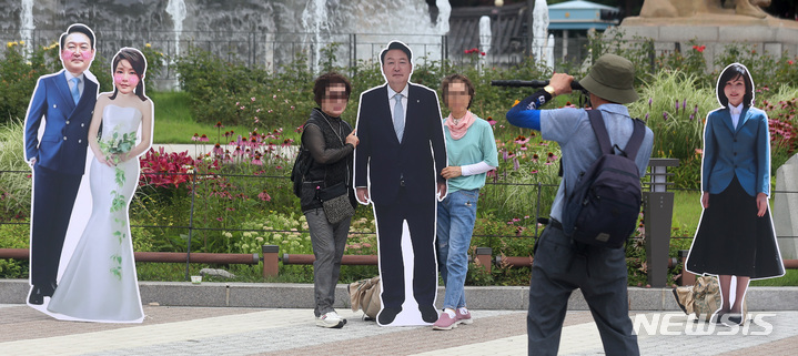 [서울=뉴시스] 이영환 기자 = 7일 오후 서울 종로구 청와대 분수대 앞에 설치된 윤석열 대통령과 부인 김건희 여사의 등신대에서 시민들이 기념촬영을 하고 있다. 2022.07.07. 20hwan@newsis.com