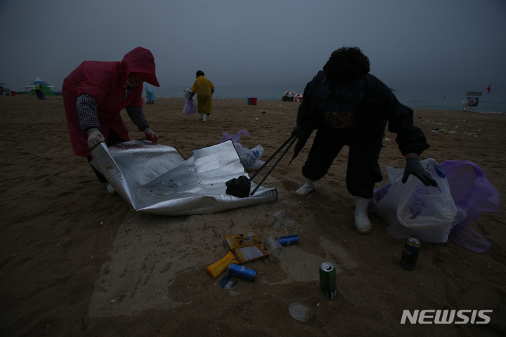 [강릉=뉴시스] 김경목 기자 = 10일 오전 미화원들이 강원 강릉시 경포해수욕장에서 밤새 쏟아져 나온 쓰레기를 수거하느라 진땀을 빼고 있다. 2022.07.10. photo31@newsis.com