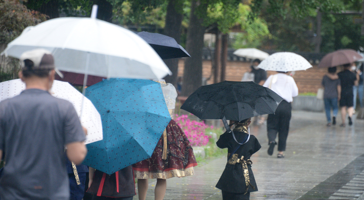 [전주=뉴시스] 김얼 기자 = 시원한 여름비가 내린 지난 13일 전북 전주시 전주한옥마을에서 시민들이 비를 피하며 길을 지나고 있다. 2022.07.13. pmkeul@newsis.com