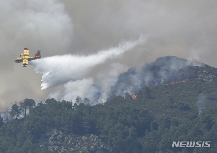 [라드리야르=AP/뉴시스] 14일(현지시간) 스페인 서부 라드리야르에서 소방 항공기 한 대가 산불 지역에 물을 뿌리고 있다. 유럽연합(EU)은 올여름 기후변화와 연관된 이상 고온 현상으로 산불이 더 만연할 것이라고 경고했다. 2022.07.15.