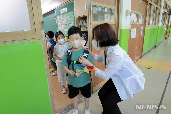 [서울=뉴시스] 조성우 기자 = 15일 오후 서울 중구 청구초등학교에서 선생님이 방학식을 마친 학생들에게 코로나19 예방을 당부하며 하교를 돕고 있다. (공동취재사진) 2022.07.15. photo@newsis.com