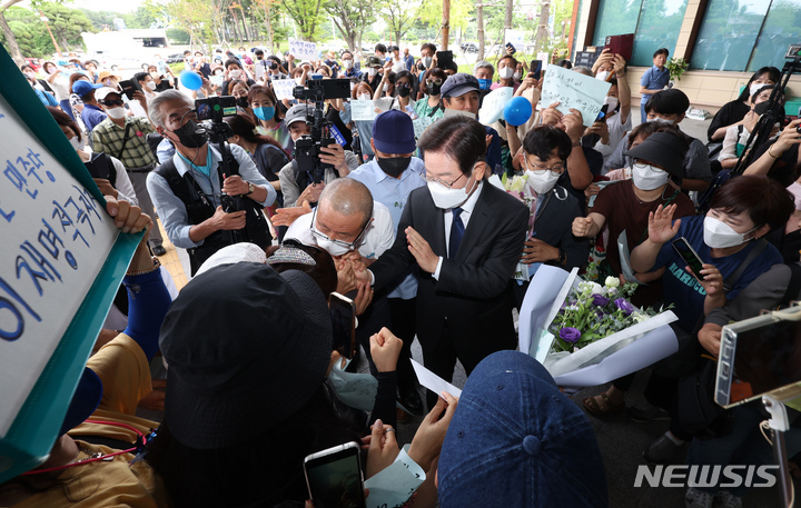 [서울=뉴시스] 김선웅 기자 = 이재명 더불어민주당 국회의원이 17일 서울 여의도 국회 소통관에서 당대표 출마를 선언하기 위해 회견장으로 향하며 지지자들과 인사를 나누고 있다. (공동취재사진) 2022.07.17. photo@newsis.com