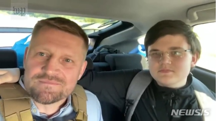 [서울=뉴시스] 지난 4월 초 러시아 군인들에게 납치돼 수용소에서 90일간 수감되었다가 살아돌아온 우크라이나 소년 블라드 부략(16·오른쪽)이 무사히 탈출한 후 아버지와 차 안에서 소감을 이야기하고 있다. (사진=워싱턴포스트 영상 캡처) 2022.07.18.