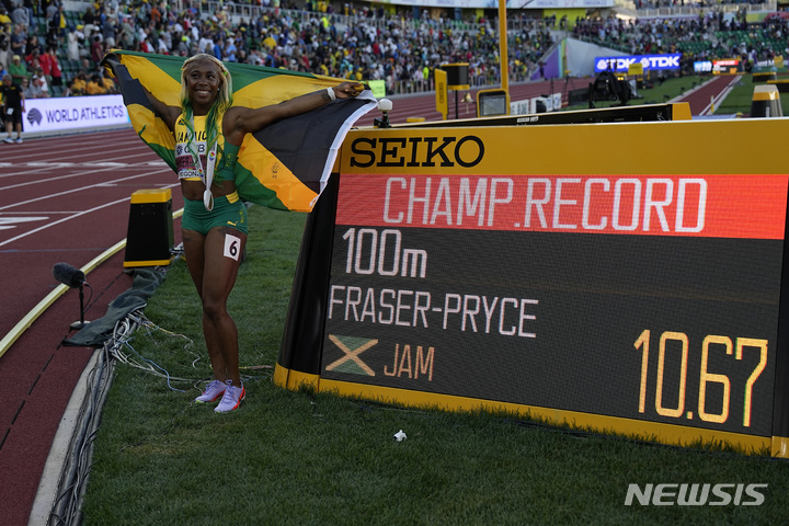 [유진=AP/뉴시스] 셸리 앤 프레이저-프라이스(자메이카)가 17일(현지시간) 미 오리건주 유진의 헤이워드 필드에서 열린 세계육상선수권대회 여자 100m에서 우승, 금메달을 목에 걸고 전광판 옆에서 포즈를 취하고 있다. 프레이저-프라이스는 10초67의 기록으로 대회 신기록을 경신하며 1위를 차지, 통산 5번째로 세계육상선수권대회 여자 100ｍ 금메달을 목에 걸었다. 2022.07.18.
