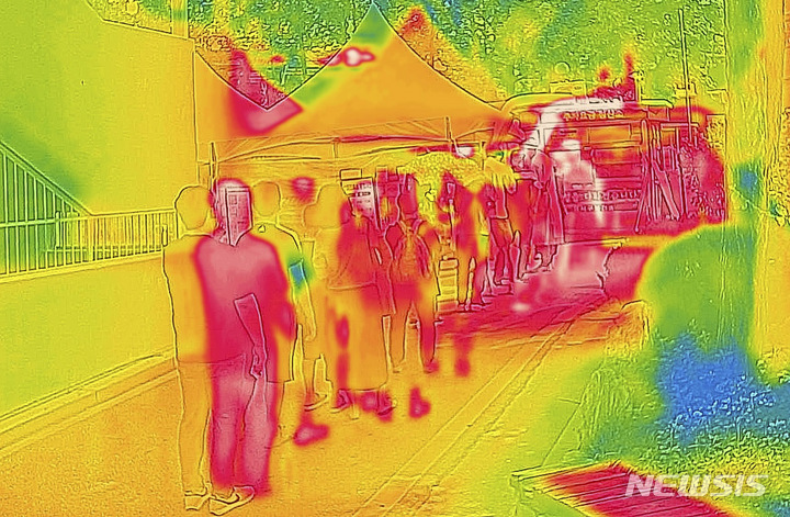 [서울=뉴시스] 정병혁 기자 = 더운 날씨가 이어진 19일 서울 강서구보건소 선별진료소를 찾은 시민들이 코로나19 검사를 받기 위해 줄 서 있다. 열화상 카메라로 촬영한 사진은 온도가 높을수록 붉은색, 낮을수록 푸른색을 나타낸다. 2022.07.19. jhope@newsis.com