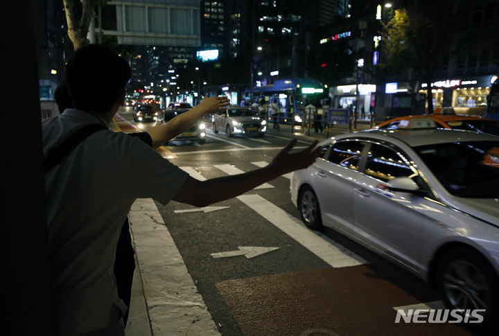 [서울=뉴시스] 고승민 기자 = 원희룡 국토교통부 장관이 심야 택시 공급을 늘리기 위해 요금과 호출료 등을 탄력적으로 올려받을 수 있게 하는 '플랫폼 택시 탄력요금제' 도입 방안을 추진키로 했다. 심야 시간대 택시 요금에 상한선을 정해 올려 운행 대수를 늘린다는 계획인데, 가격만 오르고 효과는 없어 결국 소비자 부담만 커질 수도 있다는 우려의 목소리도 나온다. 사진은 지난 19일 밤 서울 도심에서 시민들이 택시를 잡는 모습. 2022.07.19. kkssmm99@newsis.com
