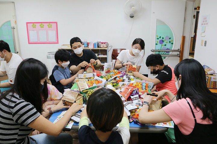 [서울=뉴시스] 에어부산 직원들이 ‘과자집 만들기 키트’를 들고 지역 아동센터를 방문해 아이들에게 즐겁고 유익한 추억을 선사했다. (사진=에어부산 제공) *재판매 및 DB 금지