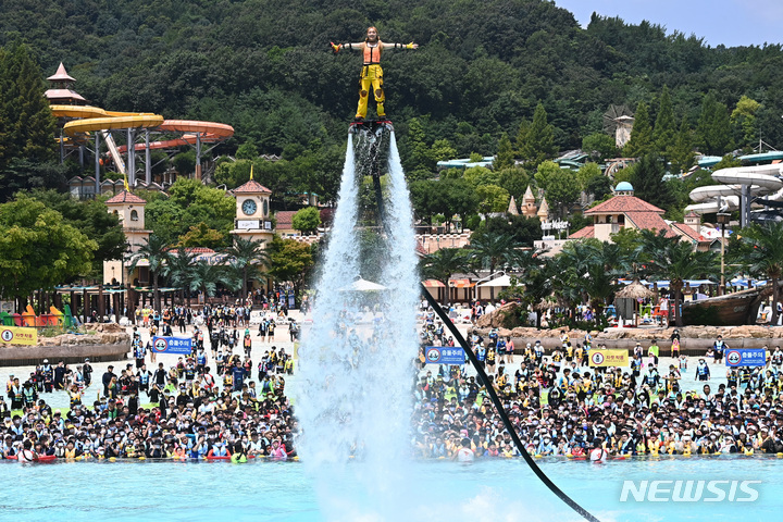 [용인=뉴시스] 김종택기자 = 전국 대부분 지역에 폭염주의보가 내려진 25일 오후 경기도 용인 캐리비안베이를 찾은 시민들이 시원한 물줄기를 뿜으며 하늘을 나는 플라이보드쇼를 보며 더위를 식히고 있다. 2022.07.25. jtk@newsis.com