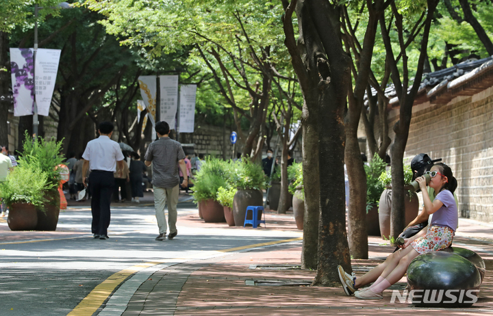 [서울=뉴시스] 김금보 기자 = 서울 전역에 폭염주의보가 내려진 25일 오후 서울 중구 덕수궁길을 찾은 시민들이 뙤약볕을 피해 나무 그늘에서 산책하고 있다. 2022.07.25. kgb@newsis.com