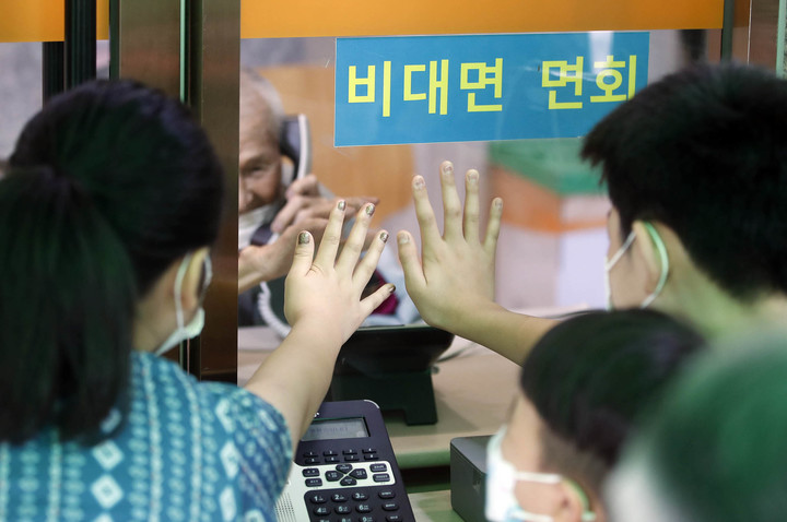 [광주=뉴시스] 코로나19 방지를 위해 요양병원·시설 내 비대면 면회만 허용되기 시작한 25일 광주 북구 중흥동 한 요양병원에서 입소자와 가족들이 유리벽 너머 인터폰을 이용해 서로의 안부를 묻고 있다. (사진=광주 북구 제공) 2022.07.25. photo@newsis.com *재판매 및 DB 금지