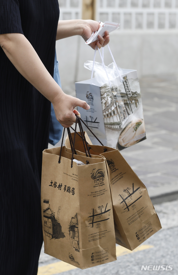 [서울=뉴시스] 고승민 기자 = 중복인 26일 서울의 한 삼계탕 식당에서 한 시민이 삼계탕을 포장해 가고 있다. 2022.07.26. kkssmm99@newsis.com