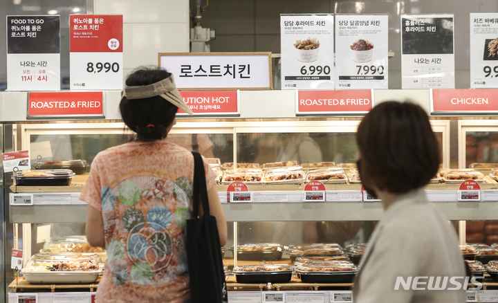 [서울=뉴시스] 김근수 기자 = 프렌차이즈 치킨 값 인상과 배달비가 급등해 유통업계가 저렴한 대체 상품을 내놓은 26일 오후 서울시내 한 대형마트에서 시민들이 7000원대 치킨을 고르고 있다. 2022.07.26. ks@newsis.com