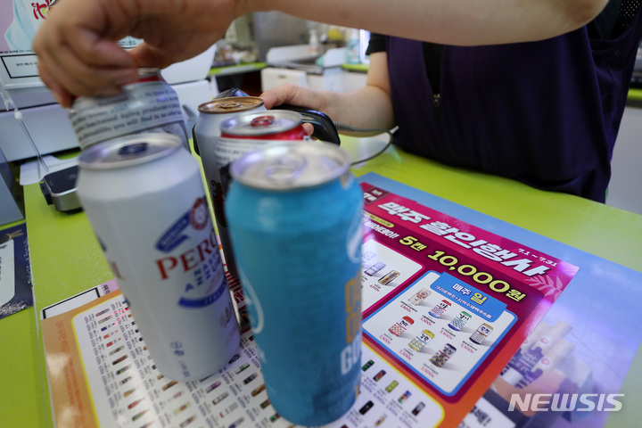 [서울=뉴시스] 백동현 기자 = 편의점 업계가 여름 성수기를 맞아 주력 상품인 맥주를 두고 치열한 초특가 경쟁이 한창이다. 29일 업계에 따르면 CU·GS25·세븐일레븐 등 편의점들은 맥주 상품을 두고 주거니 받거니 100원 단위로 가격을 낮게 책정해가며 판매 경쟁을 펼치고 있다. 사진은 이날 오후 서울 시내 한 CU편의점에서 직원이 할인 행사 중인 맥주를 계산하는 모습. 2022.07.29. livertrent@newsis.com