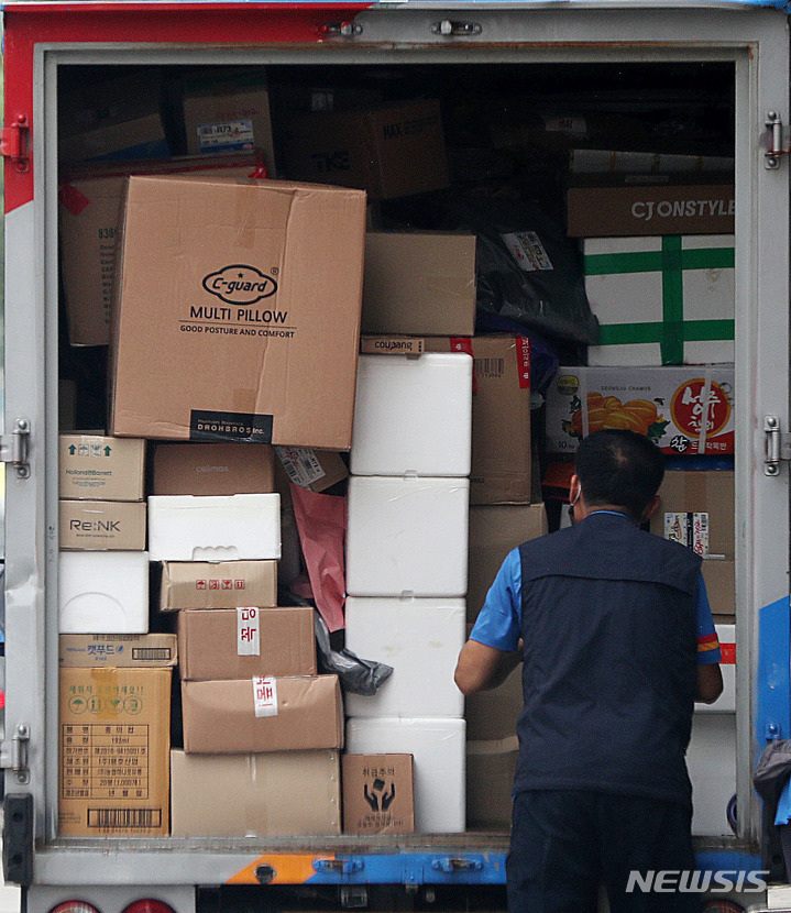[서울=뉴시스] 추상철 기자 = 서울 도심에서 택배기사가 차량소에 있는 택배 물품을 정리하고 있다. 2022.07.30. scchoo@newsis.com