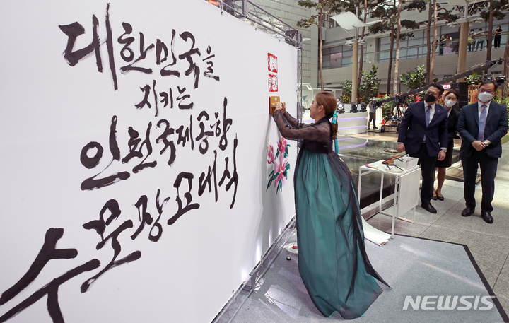 [인천공항=뉴시스] 조성우 기자 = 가수 송가인이 29일 오후 인천국제공항 제1여객터미널 밀레니엄홀에서 열린 2022년 인천국제공항 명예 수문장 임명식에서 김소영 작가의 캘리그라피 작품에 메시지를 남기는 퍼포먼스를 하고 있다. 2022.07.29. xconfind@newsis.com